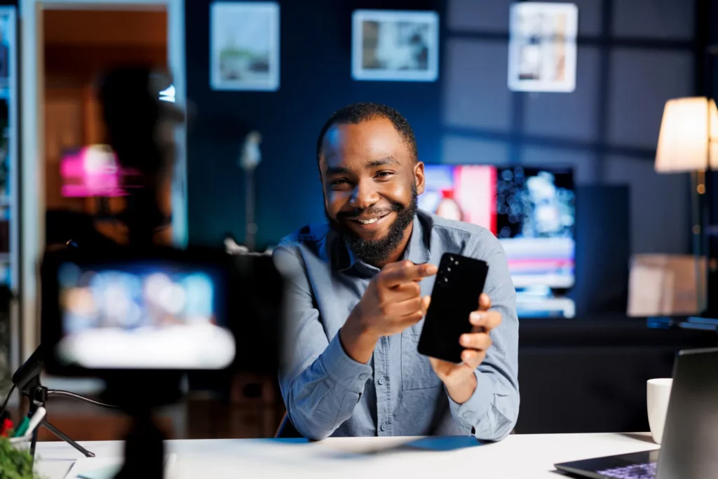 Produktpräsentation vor der Kamera mit Smartphone in der Hand